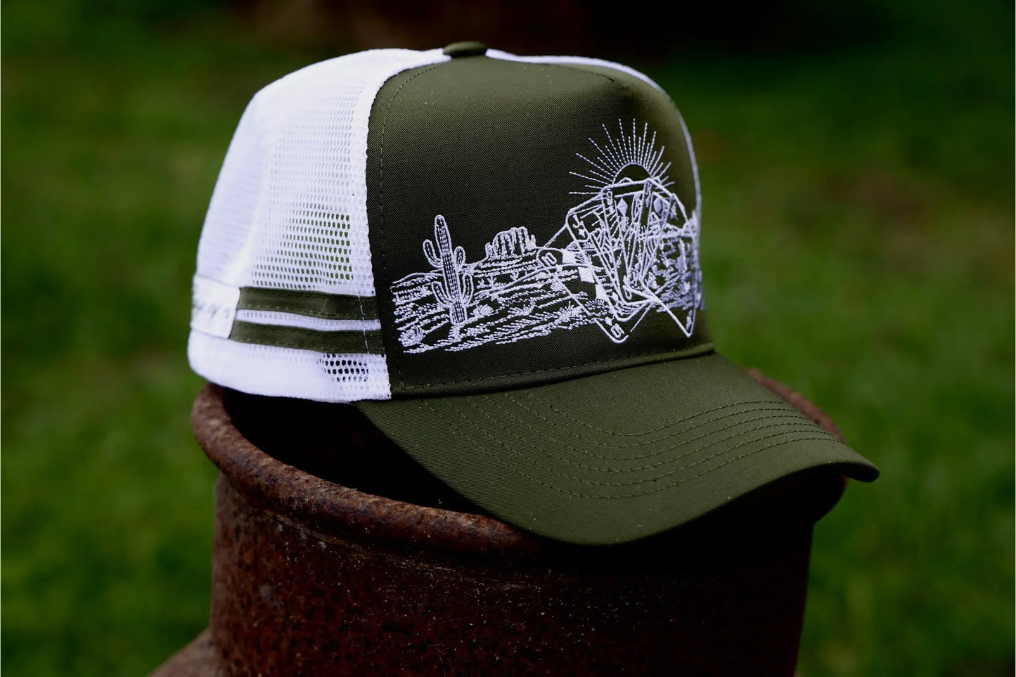 khaki green cap with with mesh & SnapBack.
White embroidered desert pattern with cards overlaid.